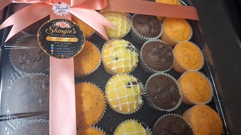 A gift box of assorted muffins tied with a blush ribbon and a Shingie's seal