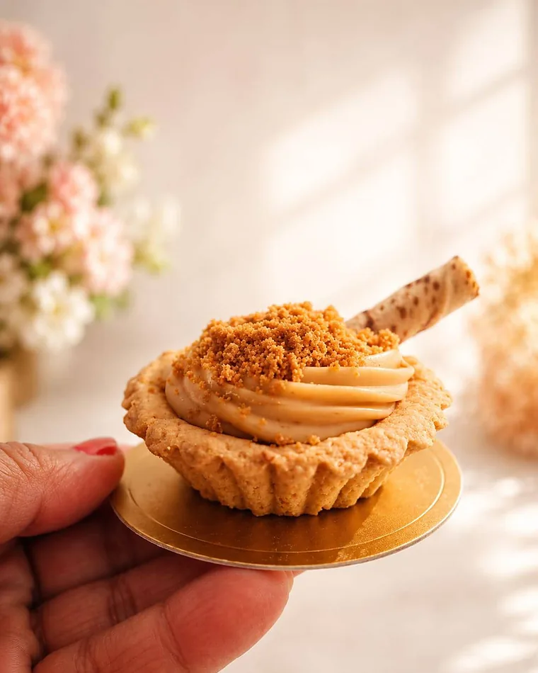 Caramel Biscoff tartlet piped with swirled caramel cream and a wafer roll